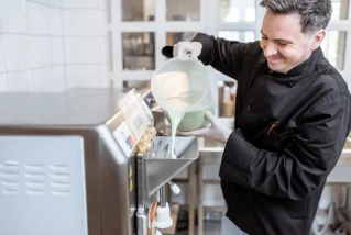 Seseorang sedang membuat ice cream dengan mesin pembuat ice cream